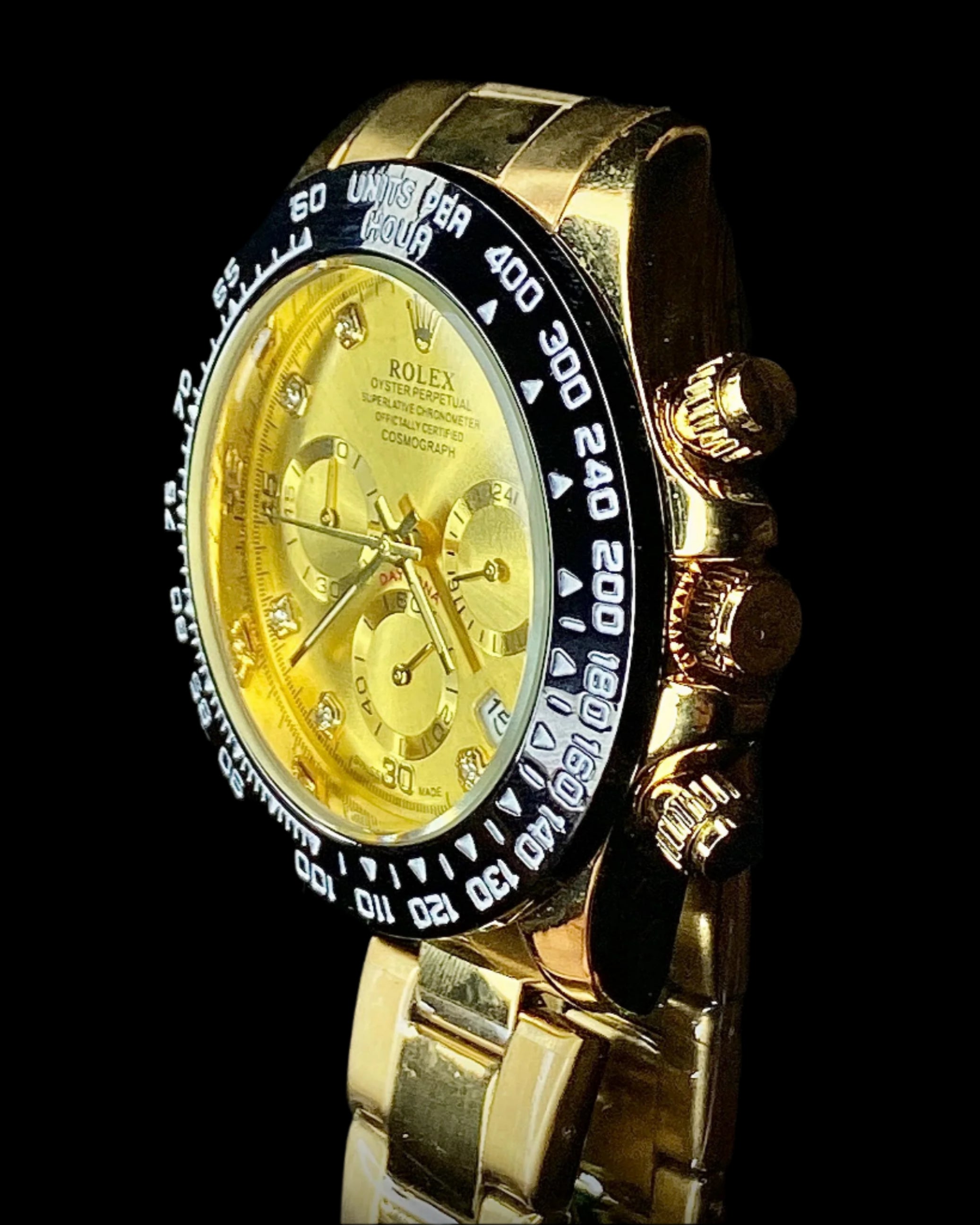 Gold Rolex watch with a black bezel on a black background